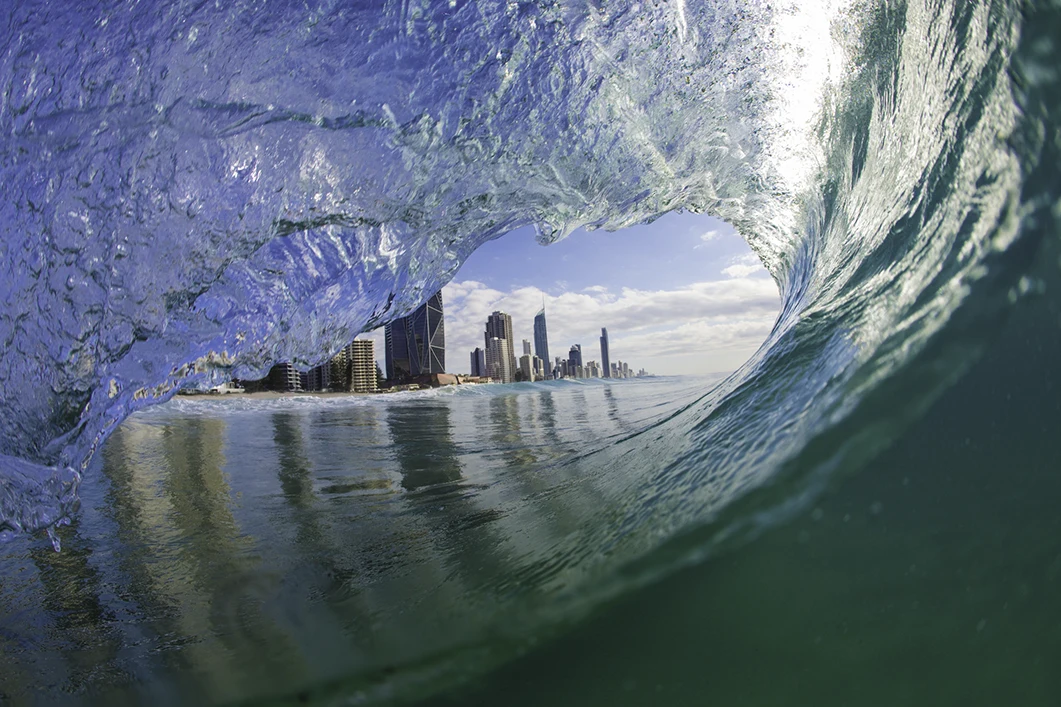 Wave crashing and view of a distant city in the middle