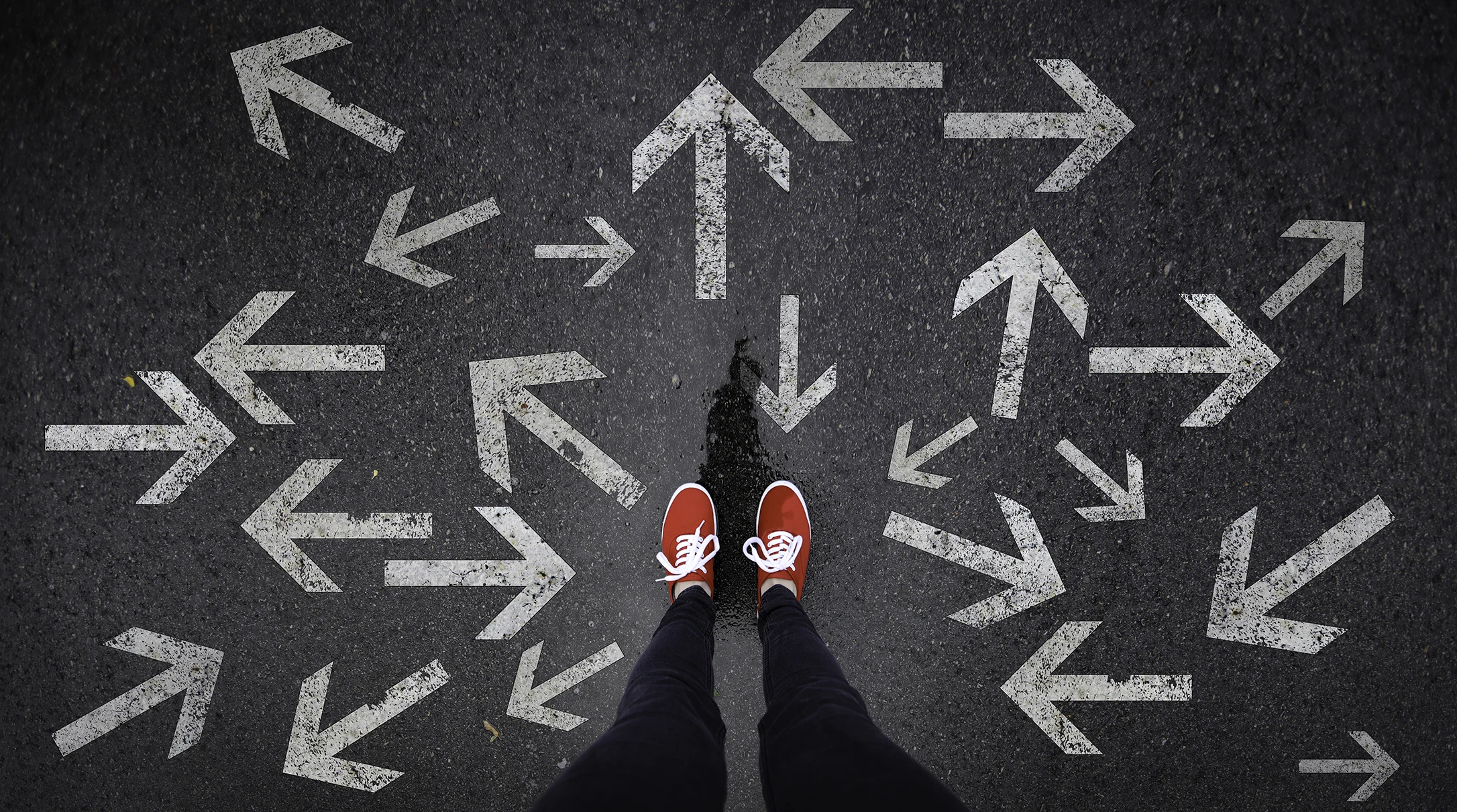 Red shoes standing next to arrows pointed in all directions