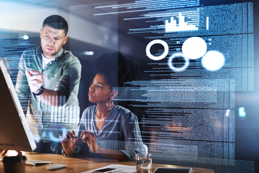 Shot of two programmers working together on a computer code at night