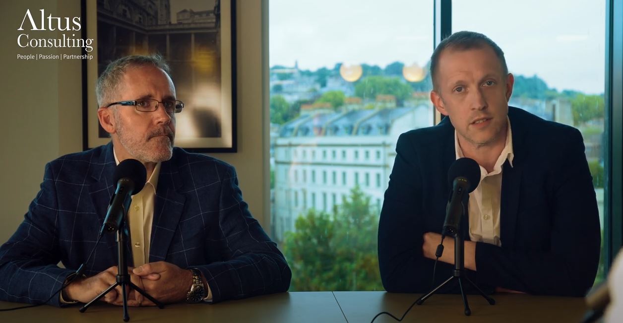 Two businessmen in front of microphones